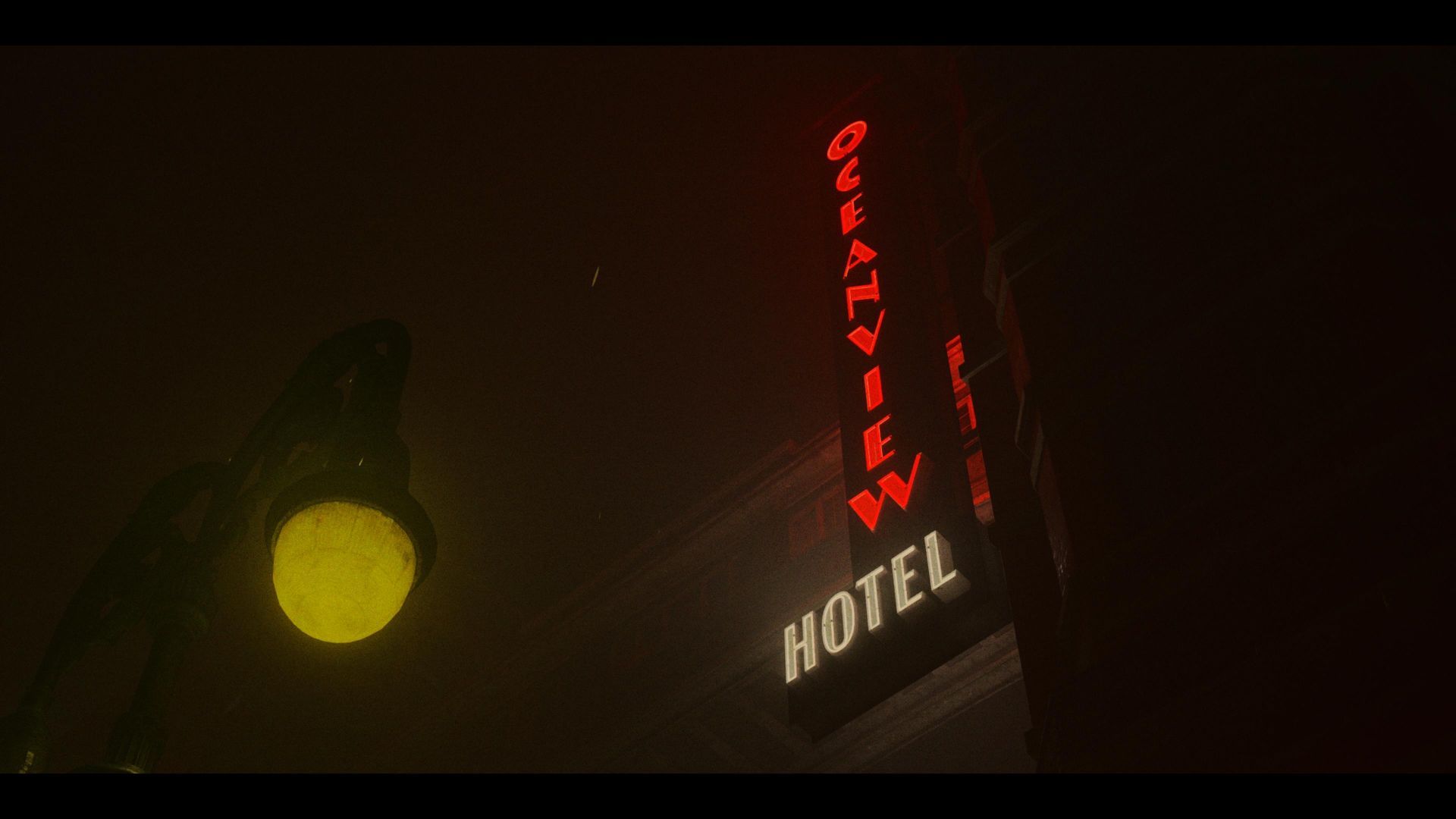 Screenshot from Alan Wake 2: A dimly lit scene featuring the illuminated sign of the 