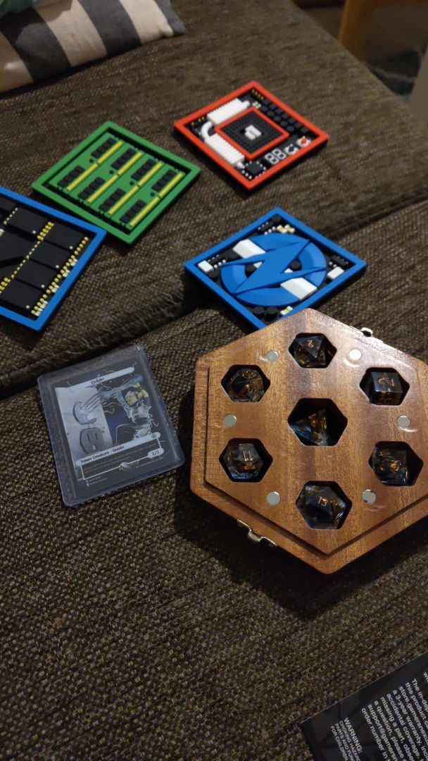 Wooden case with dice, a trading card, four computer themed drink coasters