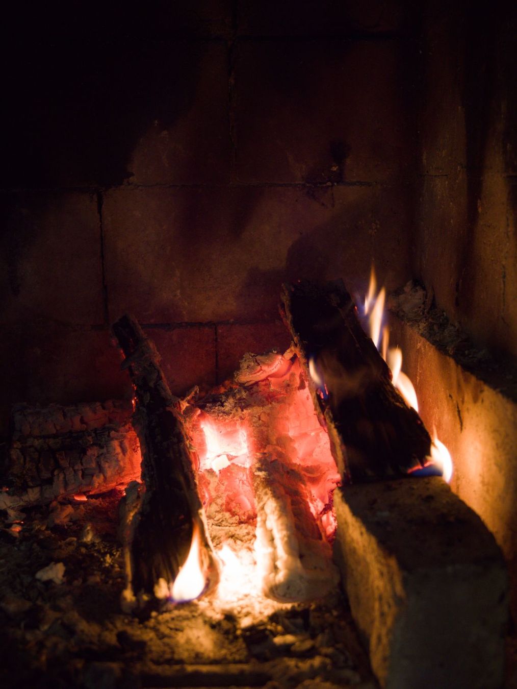 FInnish: Kuva takkatulesta. Hiillosta ja liekkejä näkyvissä. Kuva muuten hyvin tumma

English: Photo of a fireplace. Visible embers and fire. Othervise image is very dark