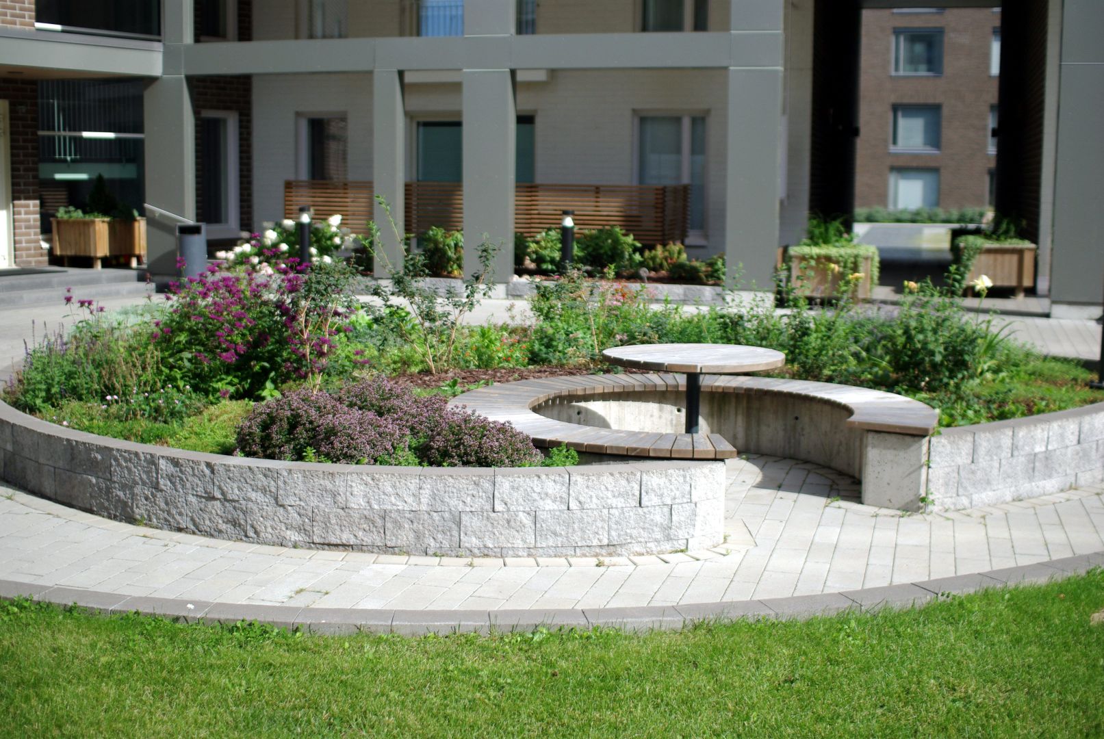 Vehreä ja kukkiva istutusalue, jossa runsaasti erilaisia perennoja.