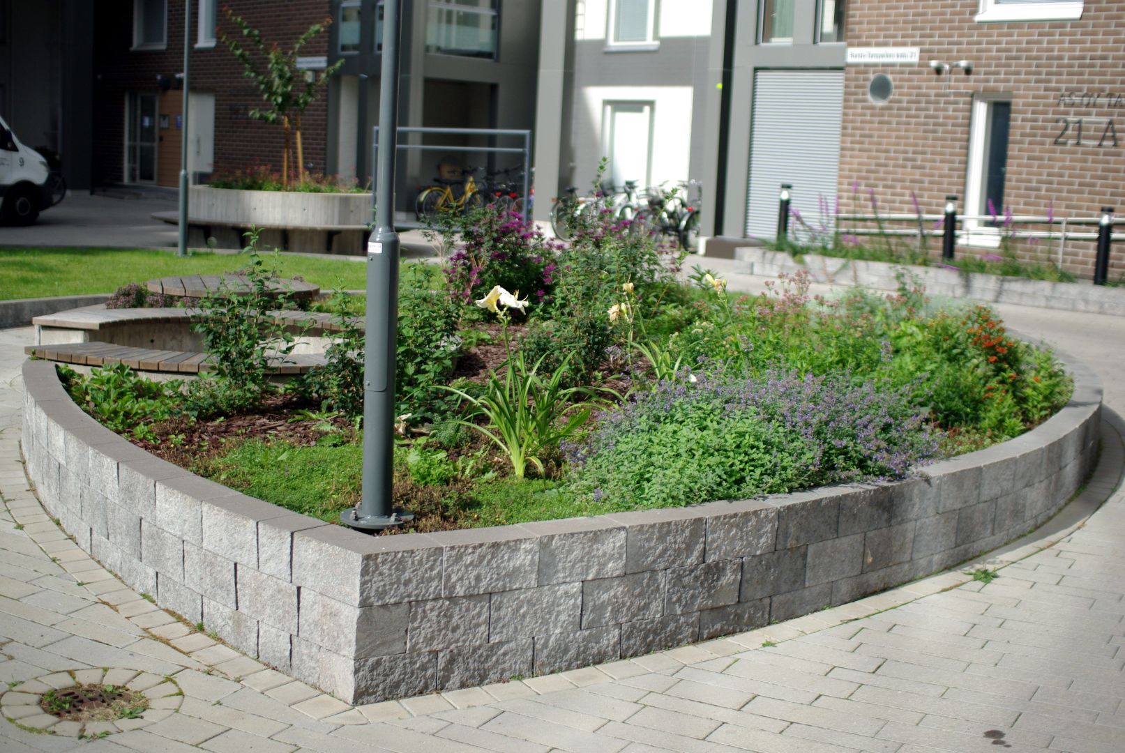 Vehreä ja kukkiva istutusalue, jossa runsaasti erilaisia perennoja.